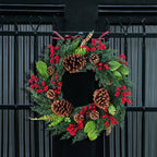 Detail van cipresgroene takken en rode bessen op de kerstkrans